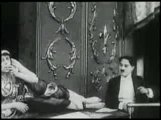 Charlie Chaplin with The Snake Charmer, one of the many acts in "A Night at the Shows"